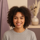 A diverse young adult smiling warmly, headshot portrait for a trust badge.